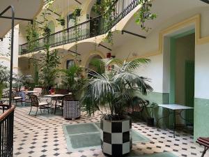 巴塞罗那半岛酒店的一座庭院,里面设有桌子和盆栽植物