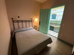 巴塞罗那半岛酒店的一间卧室设有一张床,并有通往阳台的门
