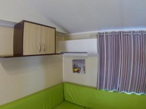 维克拉加尔迪奥勒L europe的客房设有绿色沙发和木制橱柜。