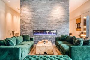 休斯顿Lodgeur at Mid Main Lofts的客厅设有绿色沙发和壁炉