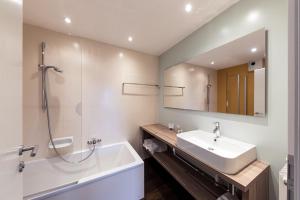 科尔皮缇亚Hotel Berghang的一间带水槽、浴缸和镜子的浴室