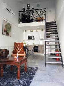 瓦拉日丁Central Luxury Apartments的客厅设有楼梯、沙发和桌子