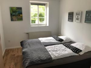 里伯Familiehuis Boysen Appartementen的一间卧室配有两张带枕头的床和窗户。