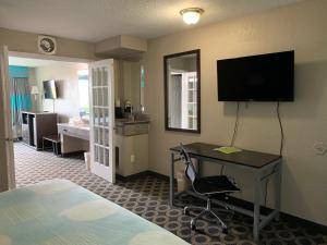 圣安东尼奥Travelodge by Wyndham San Antonio Downtown Northeast的酒店客房配有一张床、一张书桌和一台电视。