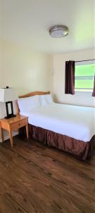 布鲁金斯蓝色海岸套房酒店的卧室配有一张白色的大床和一张桌子