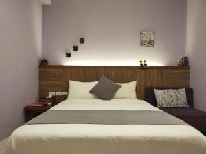 罗东镇米希格民宿的一间卧室配有一张大床和木制床头板