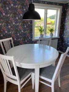 KisaYxefall Norrgården的白色的餐桌,配有椅子和吊灯