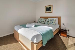 比那隆湾GRANITE BEACH HOUSE @ Bay of Fires的一间卧室配有一张带白色床单和蓝色枕头的大床。