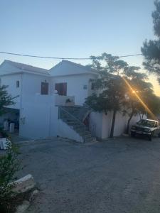 GialiskariΑΡΜΟΝΙΑ ΣΤΟΥΝΤΙΟ的前面有一辆汽车停放的白色房子
