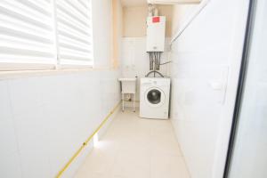 坎亚梅尔Oros de Malasigeni Bl. III 3ºA的白色洗衣房配有洗衣机和烘干机