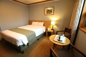 釜山普瑞玛观光酒店的酒店客房设有一张床和一张桌子