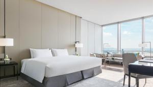 长沙长沙尼依格罗酒店的卧室配有一张白色的大床和一张沙发。
