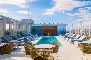 拉纳卡Hotel Indigo Larnaca, an IHG Hotel-ADULTS ONLY的一座带椅子的屋顶露台和一座位于大楼内的游泳池