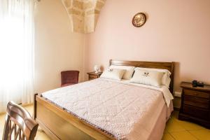 奥里亚Laurito Resort & Spa的卧室配有一张床,墙上挂着一个钟