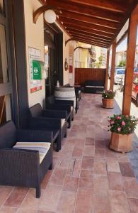 罗西尼亚诺－索尔瓦伊Piccolo Hotel的庭院里的餐厅,配有沙发和鲜花