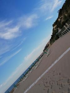 罗迪-加尔加尼科Albergo 2 Pini的海滩上设有椅子和遮阳伞,还有大海