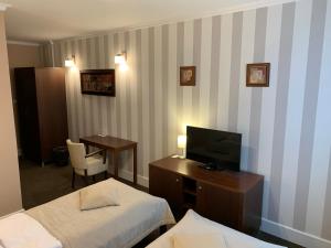 Želiezovce伊甸园宾馆的酒店客房设有两张床和电视。