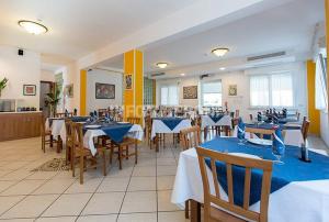 切塞纳蒂科Hotel Sasselli的餐厅配有桌椅和蓝色桌布