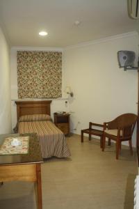 克莉丝蒂娜岛Hotel PARAISO PLAYA的卧室配有1张床、1张桌子和1把椅子