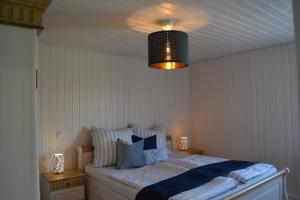 万德利茨Kapitänshaus Zerpenschleuse Holiday Chalet的一间卧室配有一张带蓝色和白色枕头的床