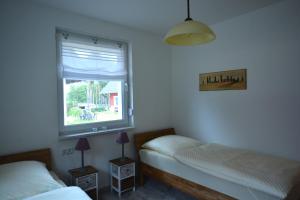 WustrowUrlaub am Plätlinsee - Haus Odin的一间卧室设有两张床和窗户。