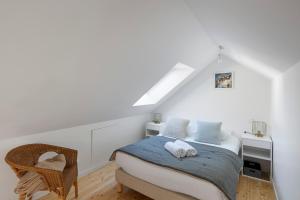 雷恩LA DEROBEE - Havre de paix en ville的白色卧室配有床和椅子