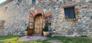 Sant Pere de VilamajorMasia Can Bachs的一座古老的石头建筑,设有木门