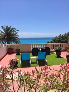 尼斯科尔斯酒店的一个带椅子的庭院和背景海洋