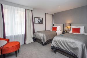 爱丁堡Ten Hill Place的酒店客房,设有两张床和一张红色椅子