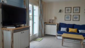 洛克马里亚Maison de vacances de 56 m2 dans résidence avec piscine chauffée proche plages的客厅配有电视和蓝色沙发。