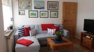 卑尔根Ferienwohnung Insel Rügen的客厅配有带红色枕头的灰色沙发