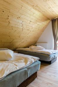 日基Domki Pod Czarnym Groniem的配有木天花板的客房内的两张床