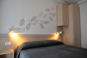 茨雷斯帕尔马皮诺公寓的一间卧室设有床,墙上有树叶