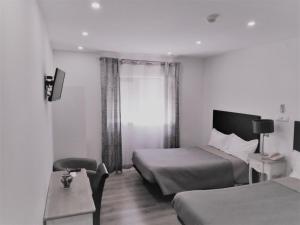 科英布拉多莫斯酒店的酒店客房设有两张床和窗户。