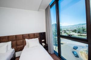 第比利斯闪耀宫酒店的酒店客房设有两张床和大窗户。