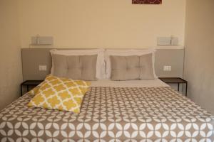 圣维托罗卡波San Vito Accommodations的一间卧室配有一张大床,上面有黄色枕头