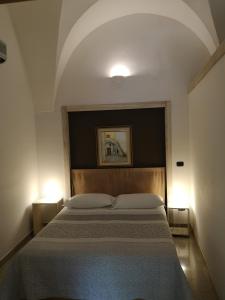 卡萨拉诺B&B Corte San Giuseppe的一间卧室配有一张大床和两盏灯