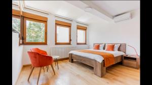 萨拉热窝Apartments RUBIK的一间卧室配有一张床、一把椅子和窗户。
