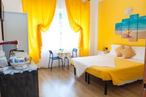 卡莫利斯特拉海滨酒店的一间卧室设有一张床和黄色的墙壁