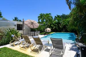 劳德代尔堡Paradise Home 3 BR with Heated Pool close to Beach的一组椅子和一个游泳池