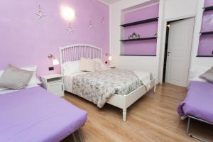 卡莫利斯特拉海滨酒店的一间卧室设有两张床和紫色的墙壁