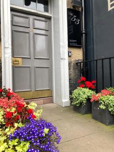 爱丁堡弗雷德里克街53号酒店的一座鲜花盛开的建筑的门