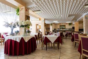 托斯科拉诺-马德尔诺亚德里亚度假酒店的餐厅设有红色和白色桌布桌