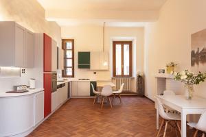 曼托瓦Casa Iolanda的厨房配有白色橱柜和桌椅