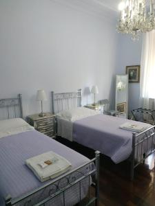 罗马Around The Corner Colosseo B&B的一间卧室配有两张床和吊灯。