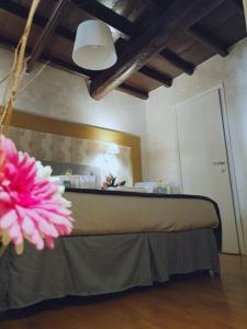罗马万神殿杜尔奇斯酒店的一间卧室配有一张粉红色花卉床