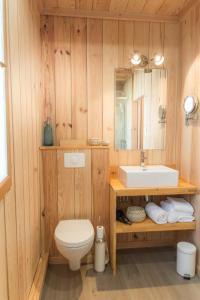 卡普费雷Centre Cap-ferret, les chambres du phare, bassin的浴室配有白色卫生间和盥洗盆。