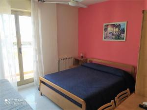贾迪尼-纳克索斯艾里赛奥酒店的一间卧室设有蓝色的床和红色的墙壁