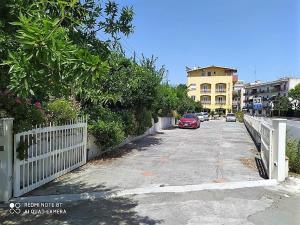 贾迪尼-纳克索斯艾里赛奥酒店的一条有白色围栏和红色汽车的街道