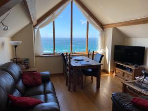 巴茅思美丽威尔士度假屋的客厅配有桌子,享有海景